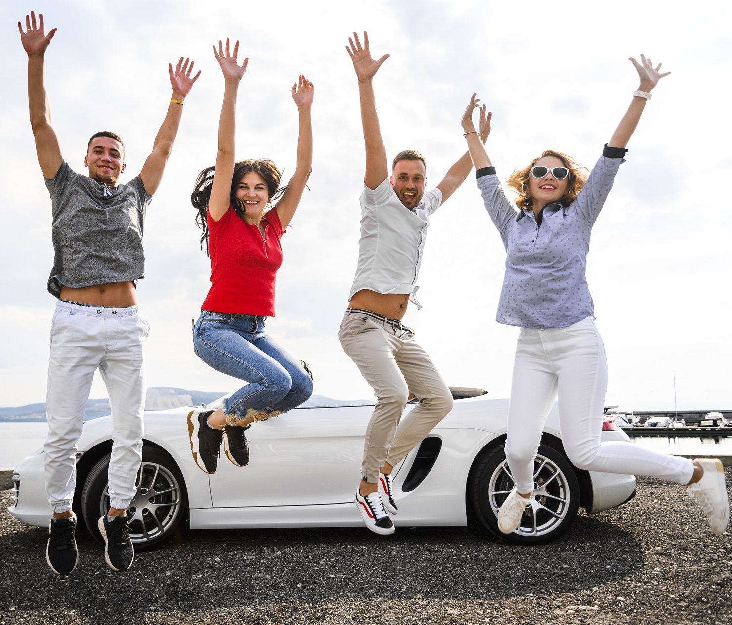 2 couples jumping in excitement in front of a car-Car Insurance in Michigan