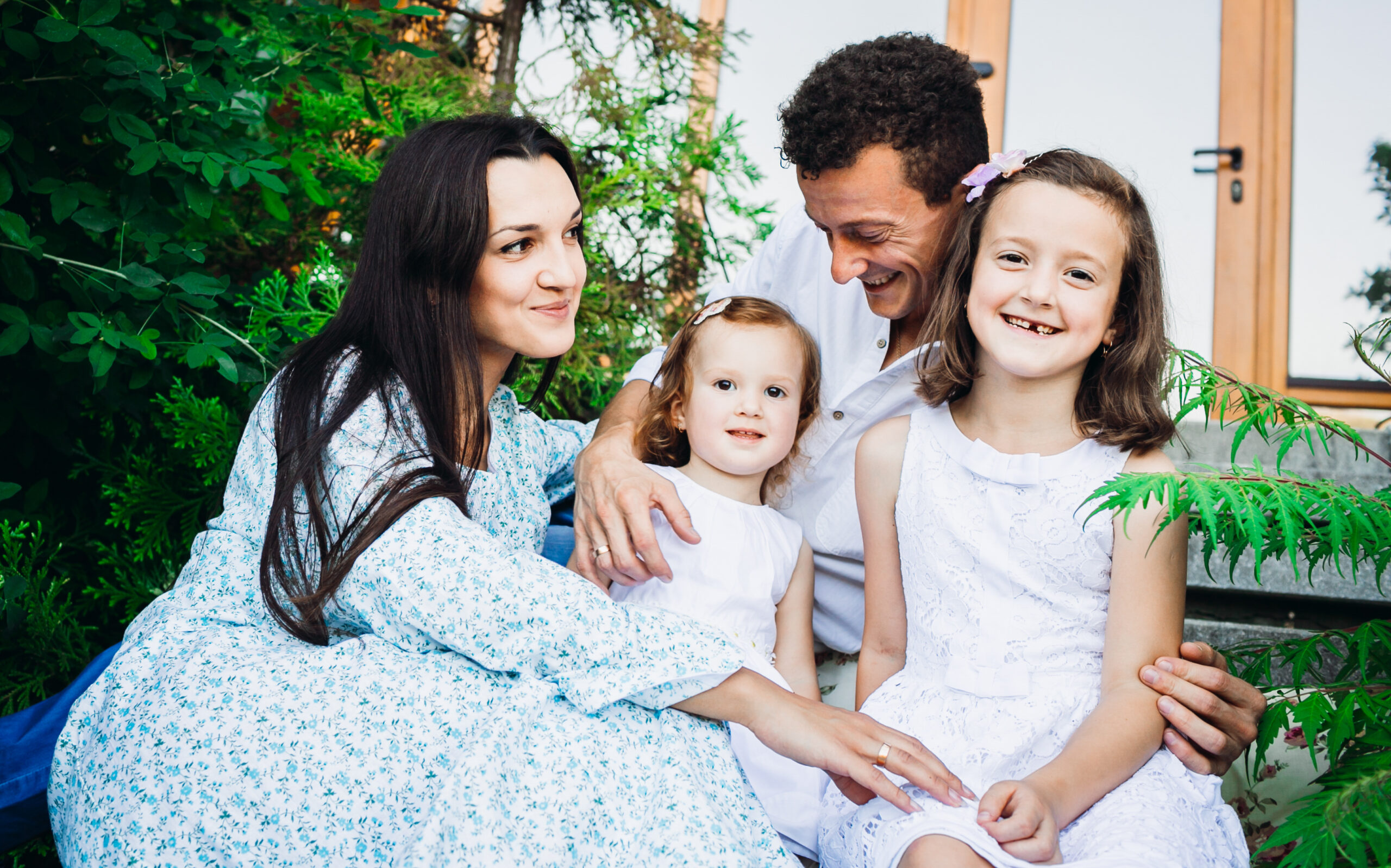 Beautiful brunette woman hugs her little daughters and husband s-Life Insurance in Michigan